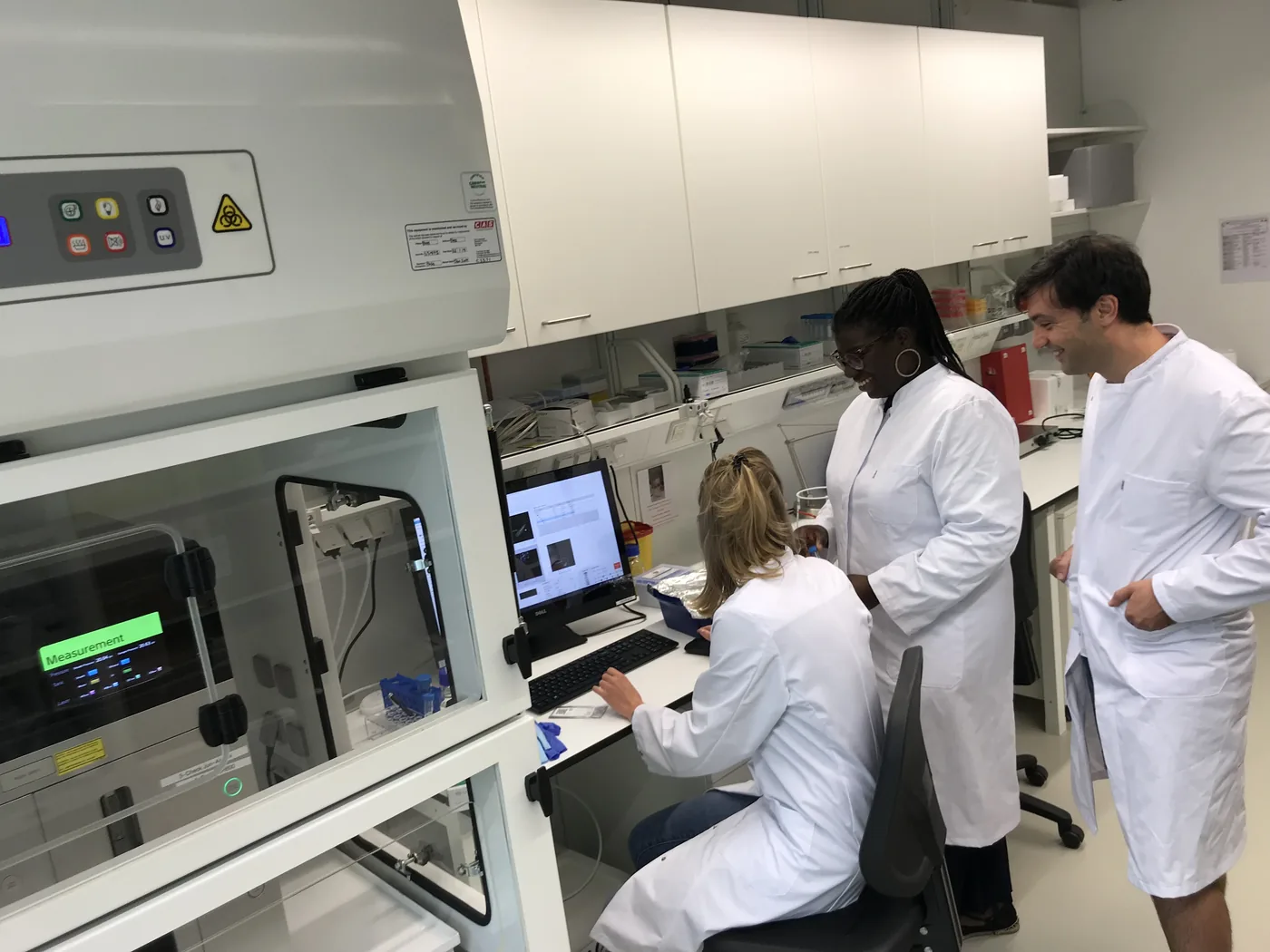 Three lab members at the sequencing bench