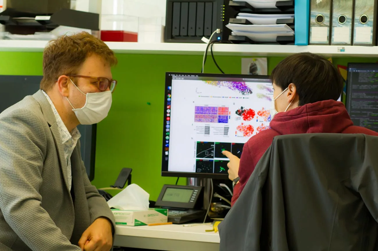 Two lab members going through single-cell data together at a screen