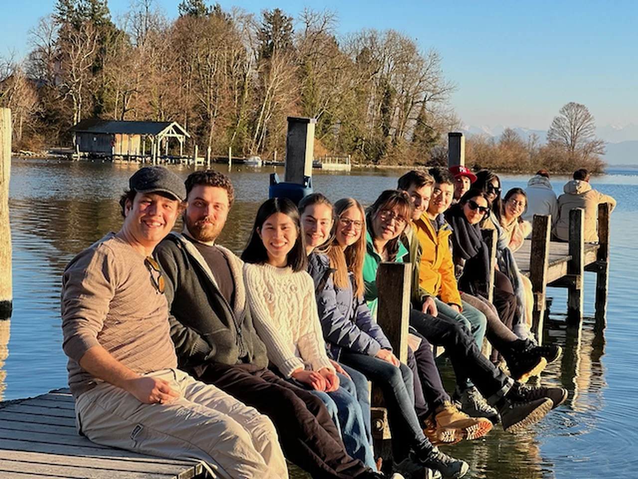 The lab sitting along a jetty by a lake on a lab outing